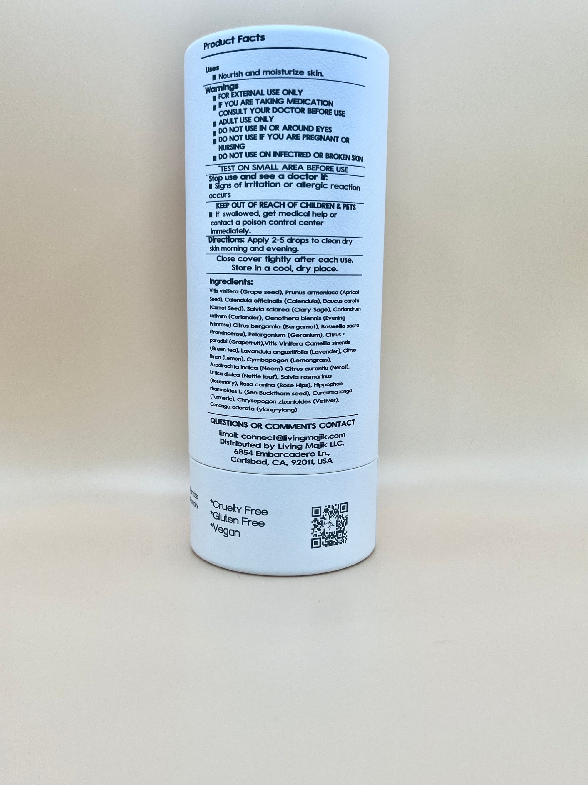 Picture of the back of Livingmajik's high-end Nourishing Botanical Facial Serum white tubular box made of recycled material with product information such as: directions on use, warnings, ingredient list, contact information, QR code, Cruelty-free, Gluten free skin care, and Vegan.